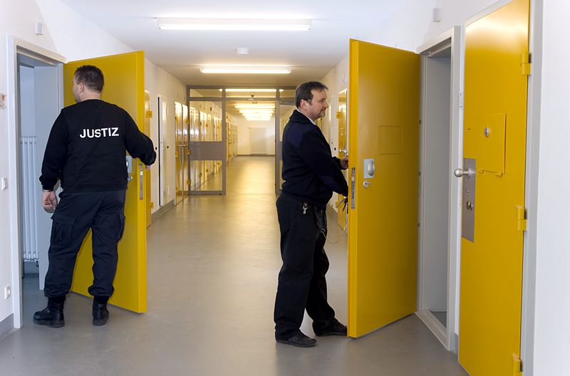Zellentrakt mit zwei Justizvollzugsbediensteten Zellentrakt